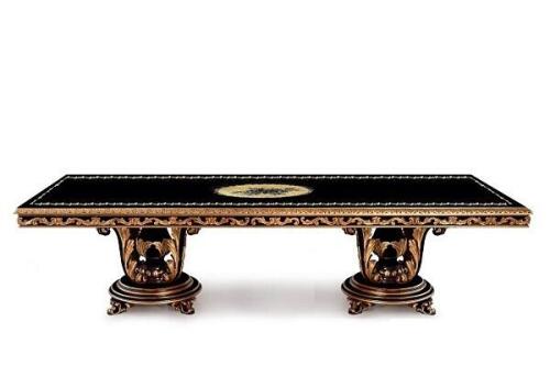 large elegant diamante style dining table in black wood with gilded decorative scrollwork and ornate carved pedestals from the Masterpiece collection at Nino Madia