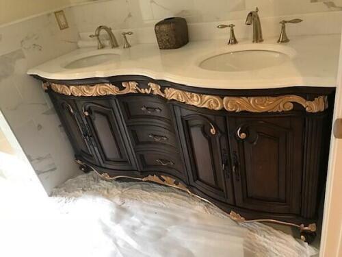 custom double sink vanity for luxury bathroom with marble top, dark wood, and gilded decorative scrollwork from Nino Madia