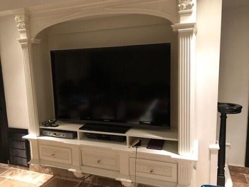 custom built in TV entertainment center with storage done in classic with columns. Designed by Nino Madia