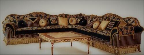 large L shaped camelback sofa with black and gold upholstery, tassel skirt, and matching square wood coffee table from Nino Madia