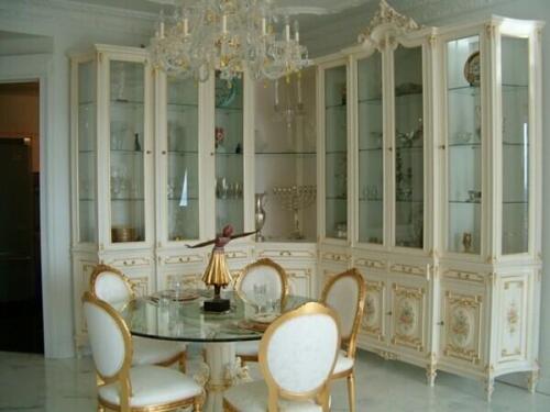 traditional french reproduction dining room table from Nino Madia with carved wood base, glass top and oval back chairs for 5 people. Matching french provincial display cabinets in L shape.