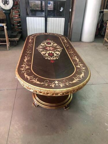 ornate dark brown wood dining table with decorative scrollwork pattern and carved gilded edge from Nino Madia