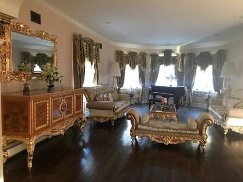custom luxury living room furniture set featuring 2 sofas, a recamier, coffee table, sideboard, and mirror with tufted cushions and matching gilding.