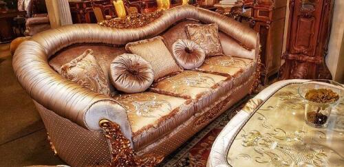 Champagne colored luxury silk camelback sofa with rolled arms, ornate carved woodwork, and matching pillows. Floor model couch for sale.