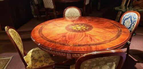 polished round wood dining table with floral inlay and decorative carved border. Floor samples for sale.
