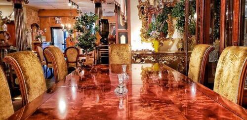 Rectangle dining room table in polished wood with 10 sleek wood dining room chairs in gold crushed velvet. Floor samples for sale.